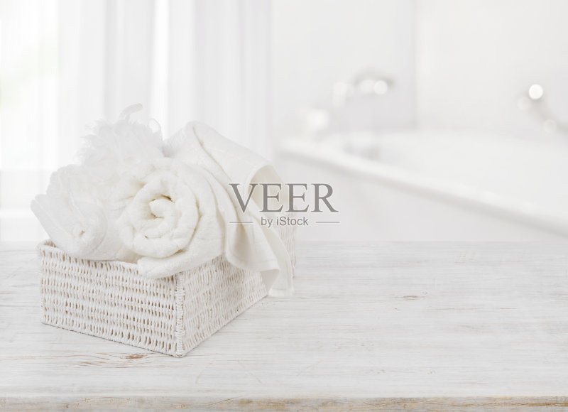 在模糊的浴室背景上的盒子里的毛巾和沐浴海绵正版图片素材