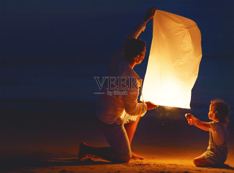 家人在海滩上飞行时送空中天光灯正版图片素材