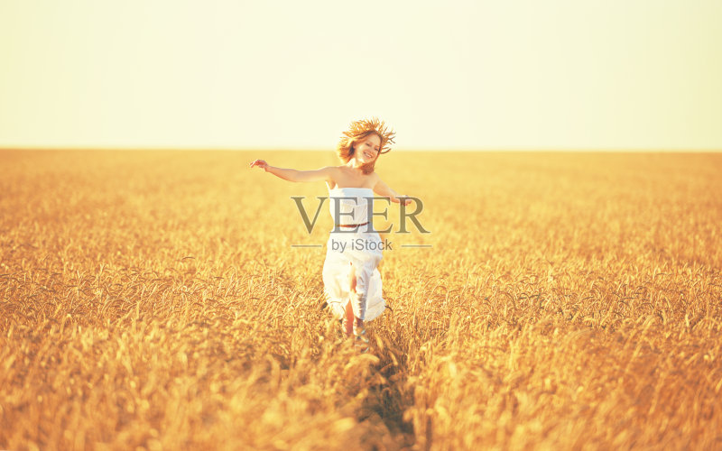 幸福的年轻女子在金色的麦田里享受生活正版图片素材