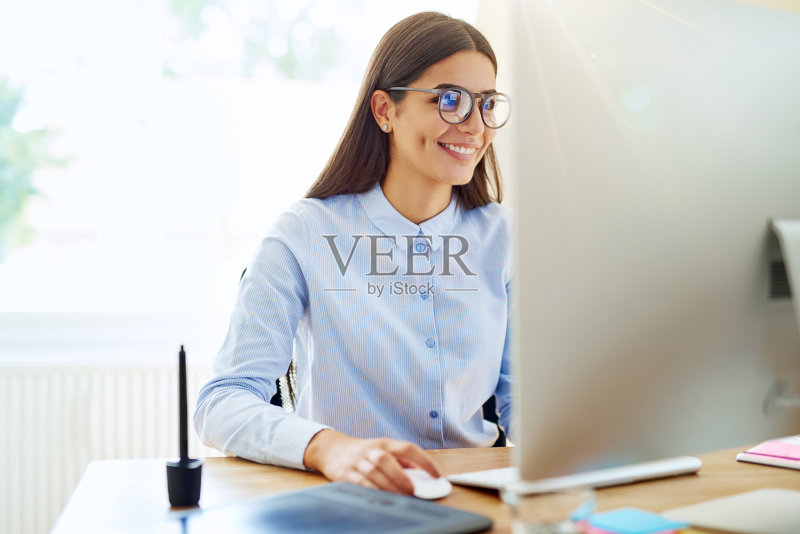 微笑的数字艺术家在电脑上工作正版图片素材