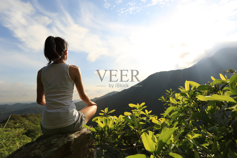 年轻的瑜伽女子在日出的山顶正版图片素材