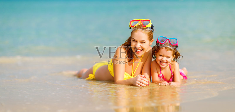 快乐的家庭妈妈和孩子戴着面具在夏天的海滩上正版图片素材