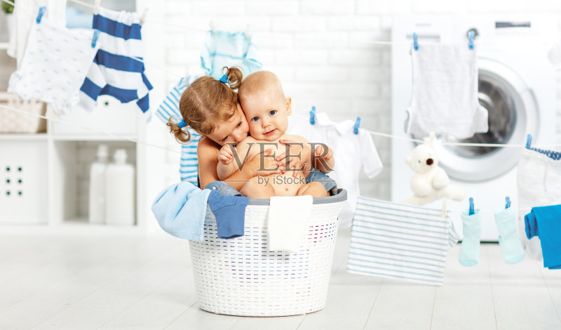 小帮手滑稽的孩子们在洗衣房洗衣服，玩着笑着正版图片素材