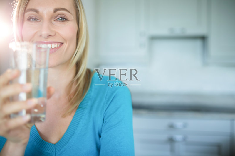 一个金发美女在喝一杯水正版图片素材