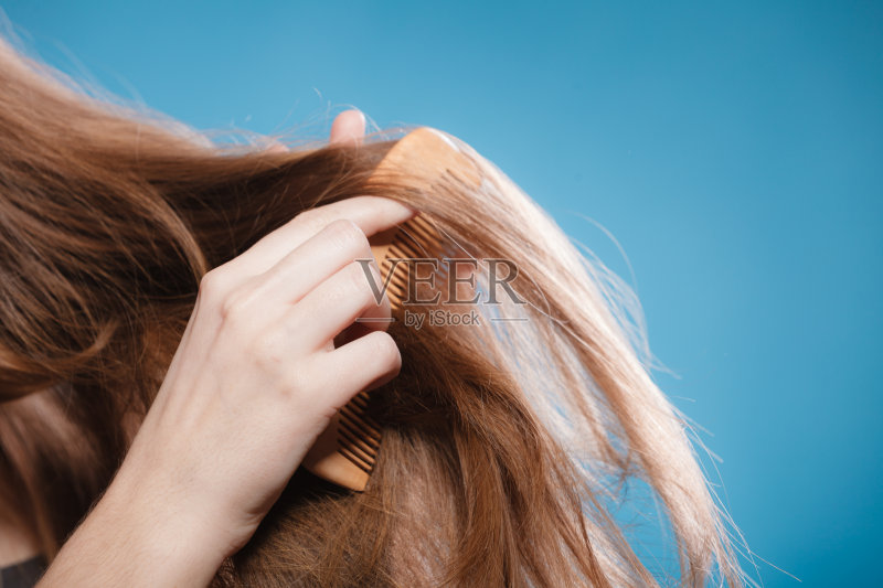 女性用手用木梳梳头发正版图片素材