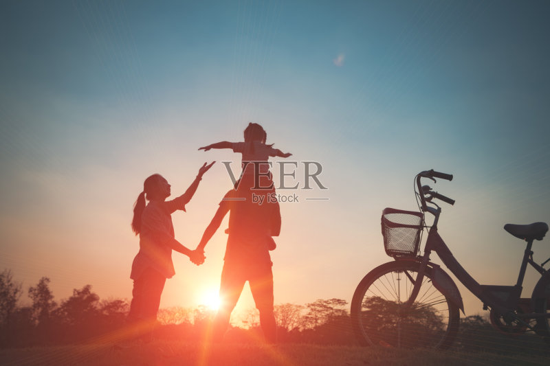 幸福的家庭在一起，父母和他们的孩子在日落。正版图片素材