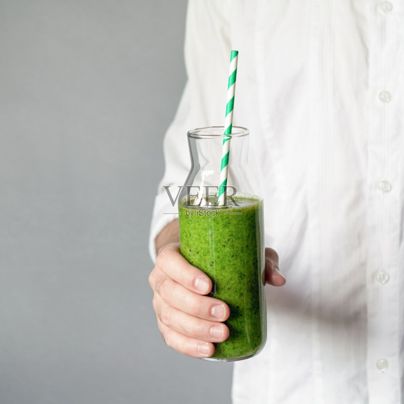 手里拿着一瓶绿色的冰沙正版图片素材