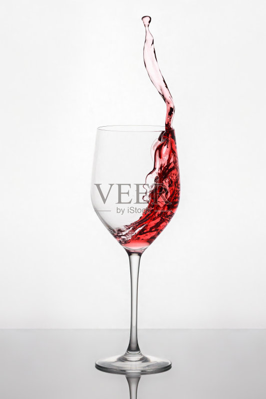 酒杯里的红酒在杯中溅起，在杯架上反射光线正版图片素材