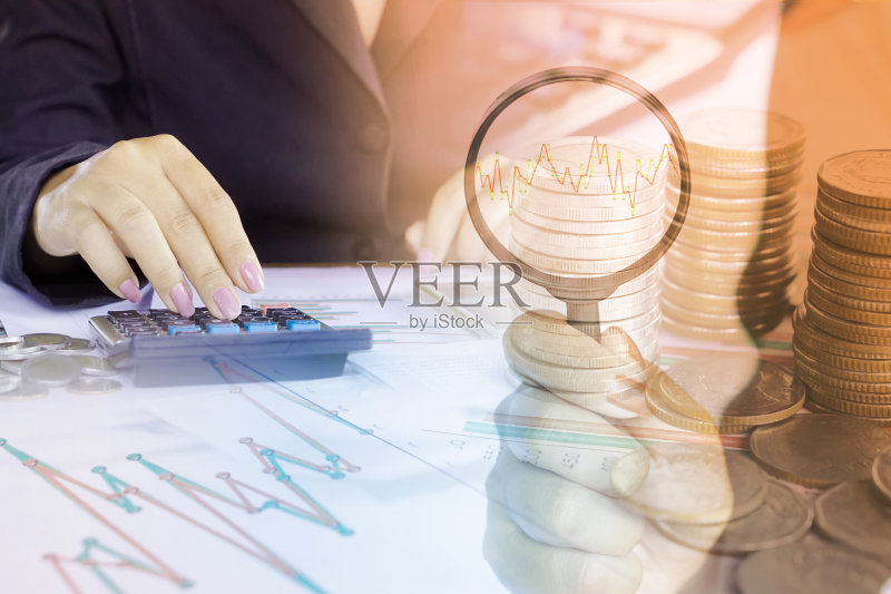 商业女性分析财务图表报告和股票图表的双重曝光，手持放大镜正版图片素材