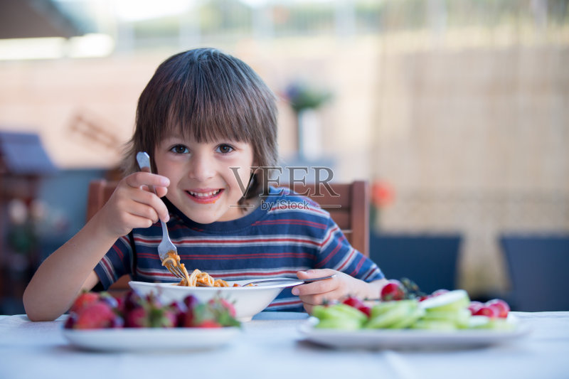 可爱的孩子，学前班的小男孩，午餐在户外吃意大利面正版图片素材