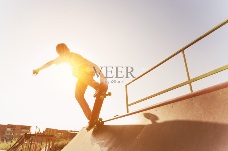 在一个滑板公园里，一个十几岁的滑板手挂在滑板的斜坡上正版图片素材