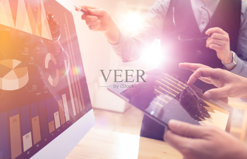 两位同事使用平板电脑和笔记本电脑制定新的全球财务战略计划。现代企业团队创新理念。项目会议在办公室与虚拟图形和图表数据接口正版图片素材