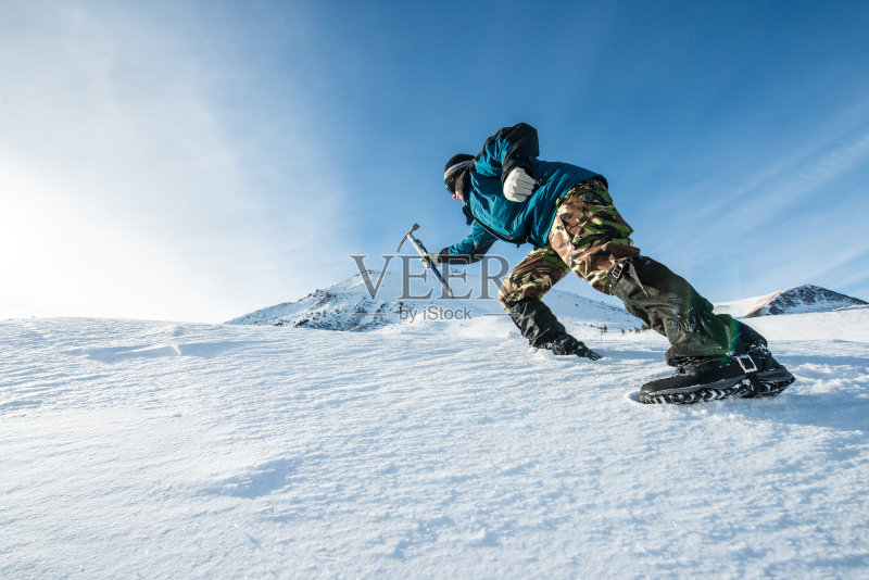 登山者拿着冰斧爬上了雪山正版图片素材