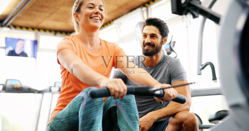 年轻漂亮的女人做运动与私人教练正版图片素材