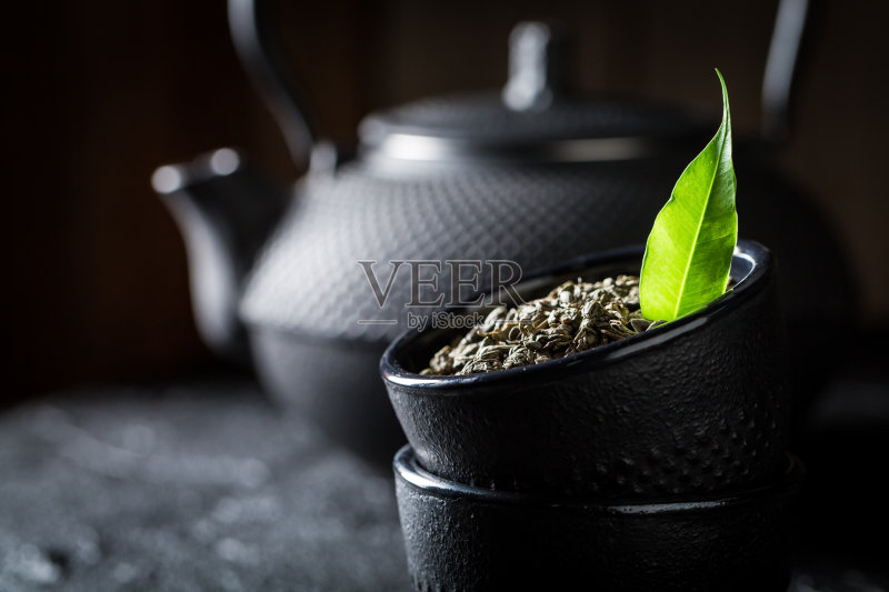 黑岩上的茶杯中的茶叶绿茶特写正版图片素材
