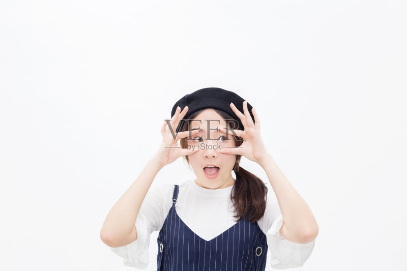 惊讶和惊讶的女性把手指周围的眼睛睁大在白色孤立的背景。正版图片素材