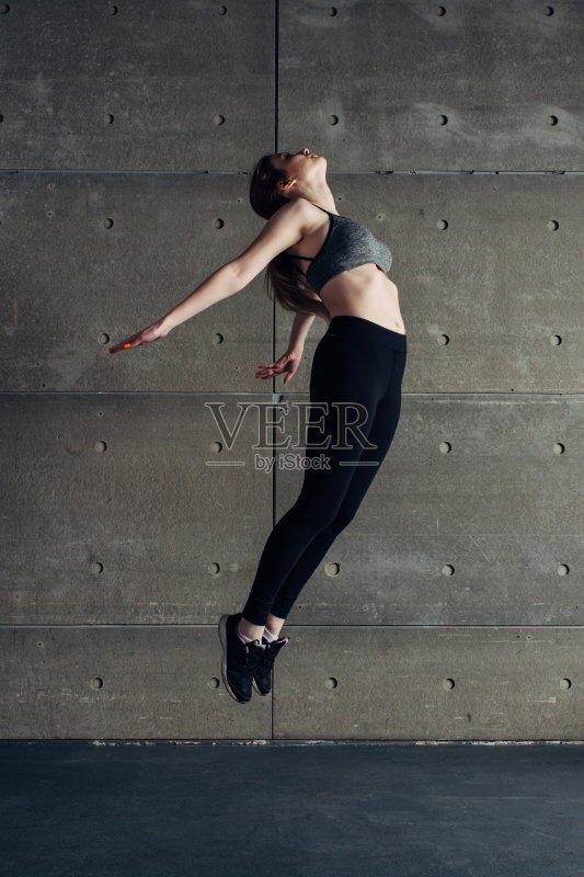 运动年轻女子做后弯跳跃正版图片素材