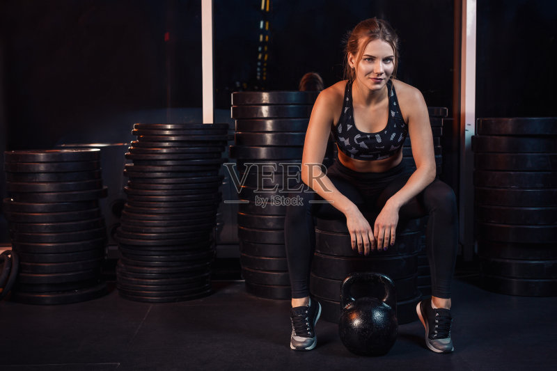 在健身房用水壶球健身的女人正版图片素材