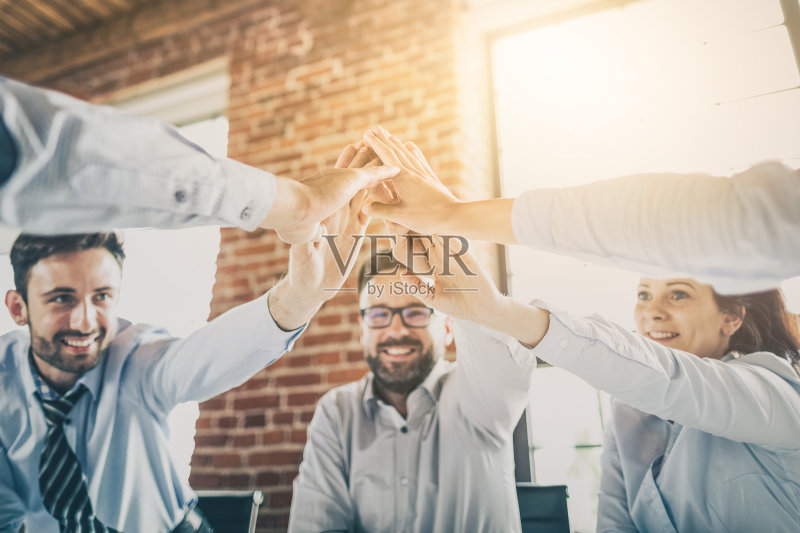快乐的商业团队在办公室击掌庆祝。正版图片素材