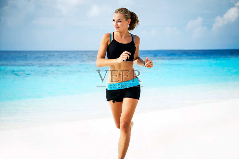 美丽的女人在沙滩上跑步正版图片素材