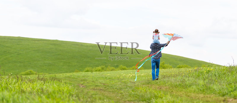 幸福的家庭父亲和小女儿在草地上追风筝正版图片素材
