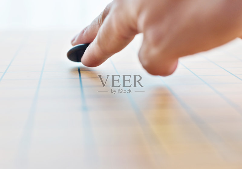 人用手把棋子放在棋盘上正版图片素材