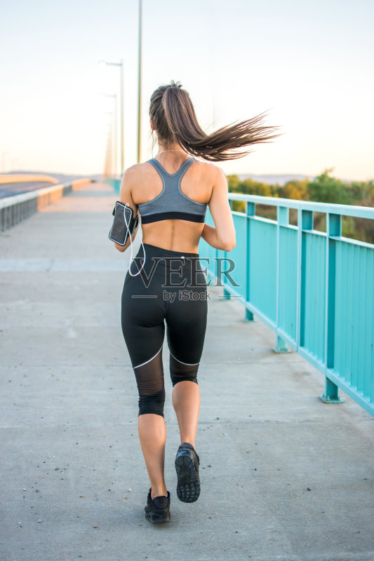 运动女人跑过桥的后视图。正版图片素材