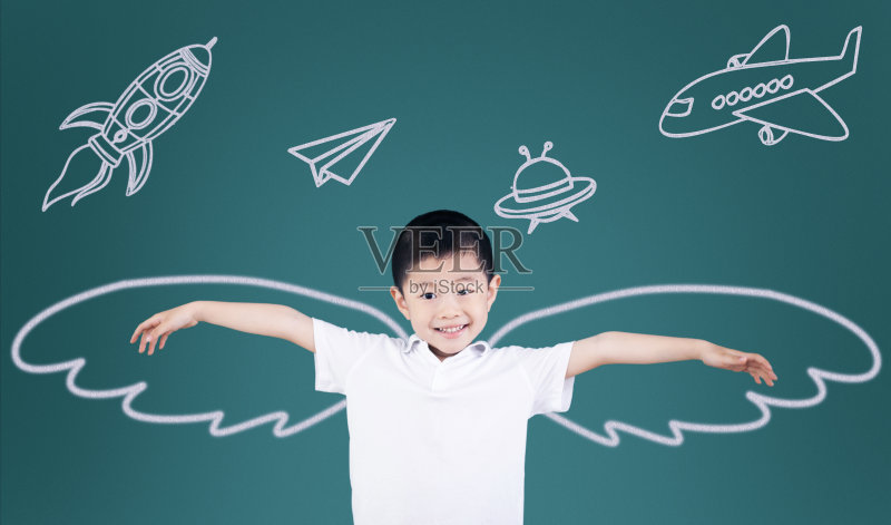 男孩举着手臂站在黑板前正版图片素材