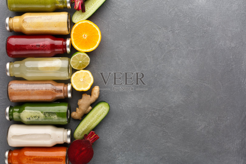 各种各样的排毒冰沙在玻璃瓶在灰色的背景。正版图片素材