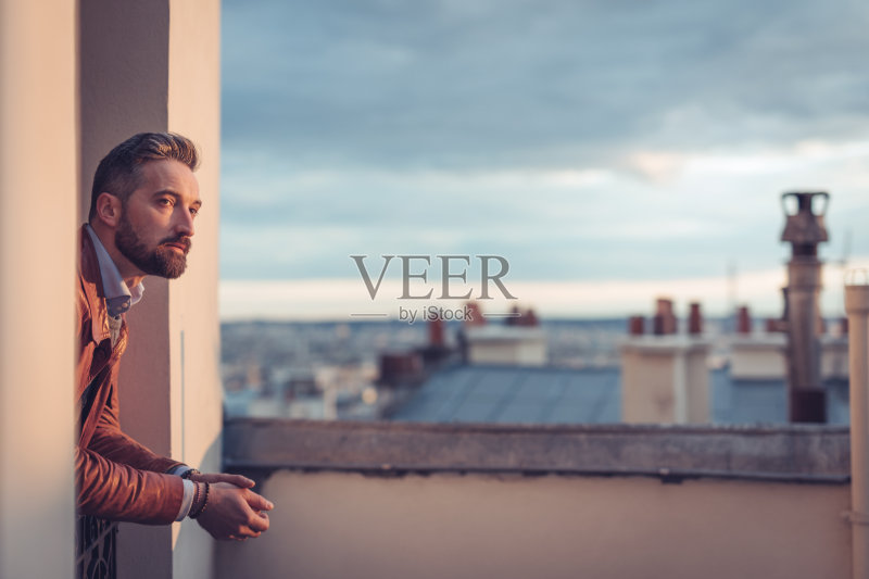 有胡子的男人在日出时眺望城市正版图片素材