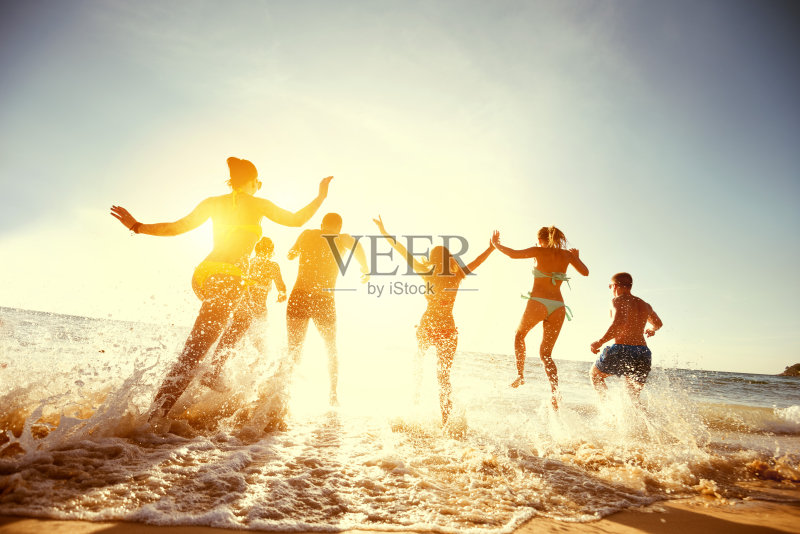 大群朋友日落海边沙滩跑正版图片素材