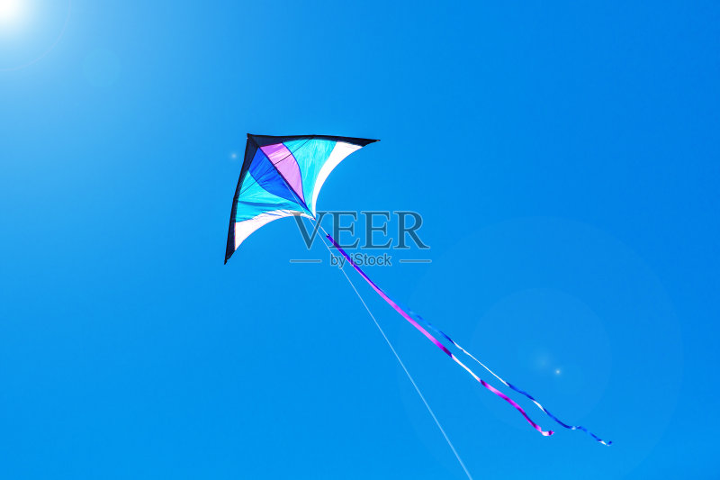 三角形的风筝在一个晴朗的日子里飞翔正版图片素材