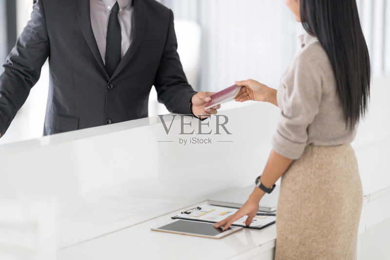 在酒店接待处或前厅登记入住的人被给予钥匙卡正版图片素材