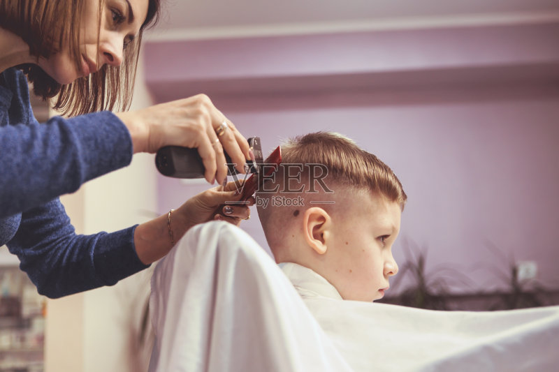 理发师的手给小男孩做发型，特写。男孩的时尚发型。正版图片素材