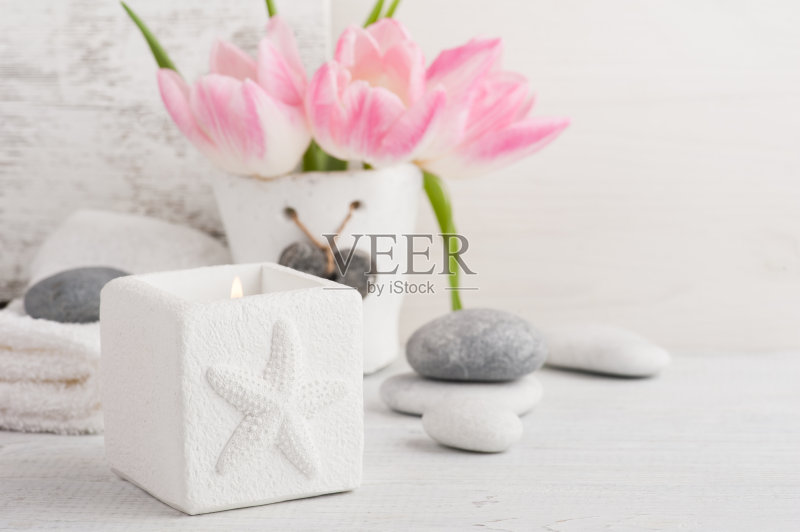 粉红色的郁金香，鹅卵石和点燃的蜡烛正版图片素材