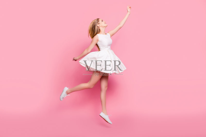 全尺寸的全长侧视图肖像，美丽迷人的，无忧无虑的，温柔的，天真的，时尚的，兴奋的，快乐的女孩跳起来想要触摸天空孤立的背景复制空间正版图片素材