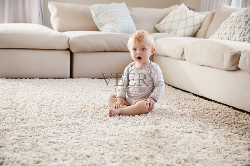 一个白人小男孩坐在客厅的地板上正版图片素材