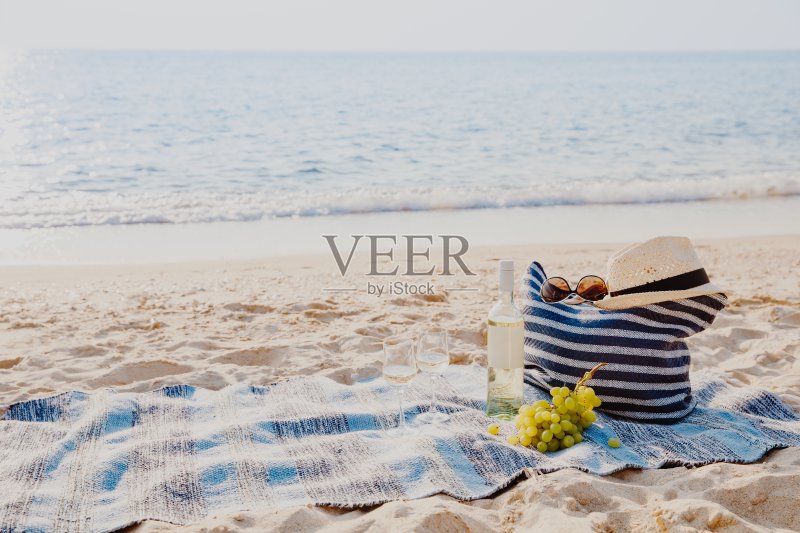 野餐背景与袋，葡萄和白葡萄酒在蓝色的大海正版图片素材