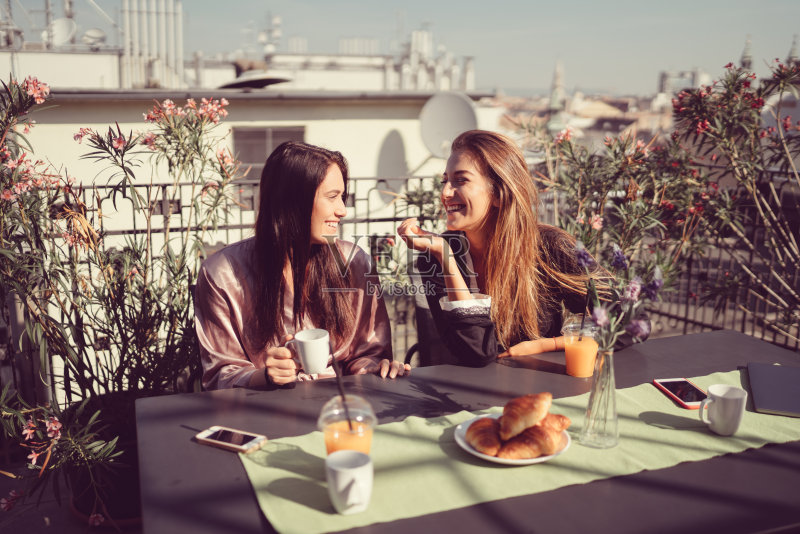 女人们在露台边喝咖啡边聊天正版图片素材