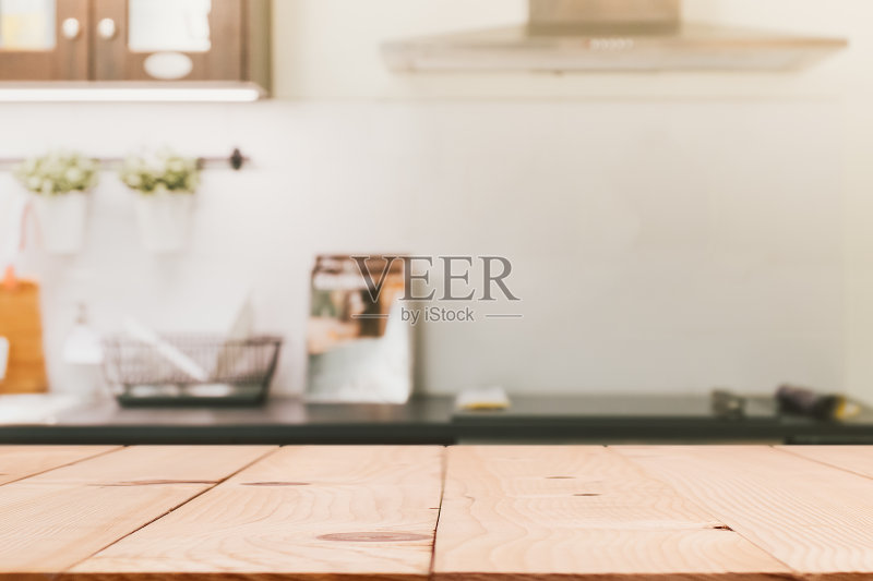 木质桌面岛与模糊的现代厨房室内背景正版图片素材