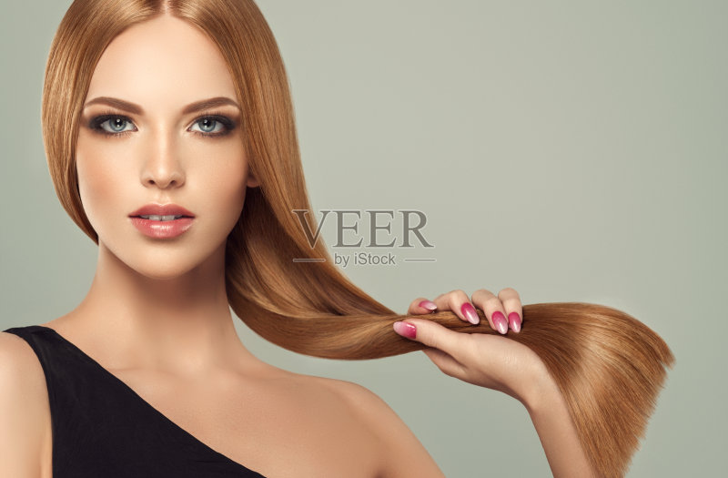 年轻，棕色头发美丽的模型，长，卷曲，整齐的头发。优秀的头发。美发艺术与护发。正版图片素材