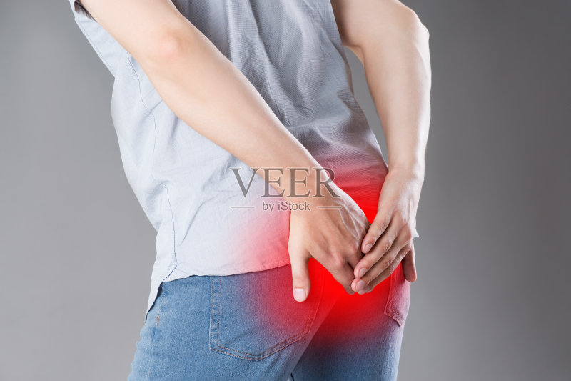 患有痔疮的男人，灰色背景上的肛门疼痛正版图片素材