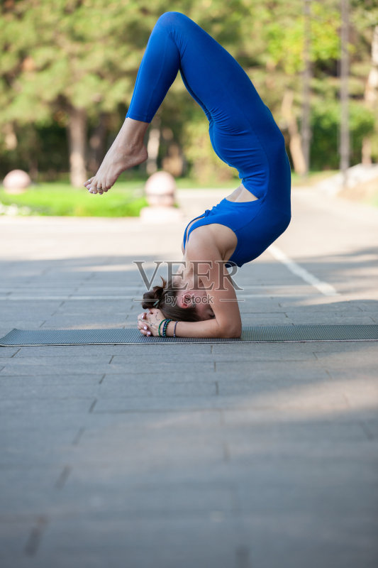女人在瑜伽垫上放松户外模糊的背景正版图片素材
