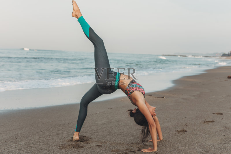 美丽的年轻女子伸展在海滩正版图片素材