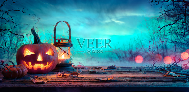 黄昏时餐桌上挂着灯笼的万圣节南瓜正版图片素材