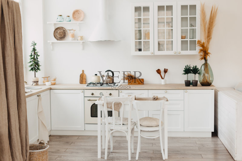 现代的新明亮的厨房内部白色家具和餐桌。正版图片素材