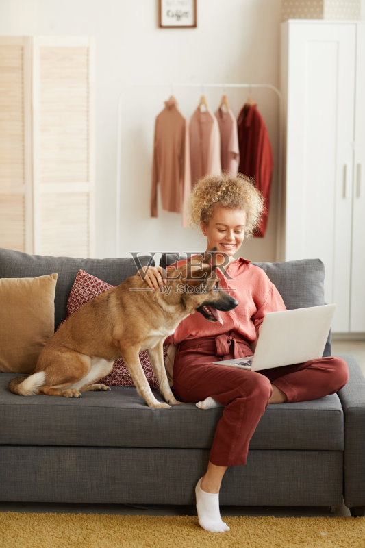 在家和她的狗一起工作的妇女正版图片素材
