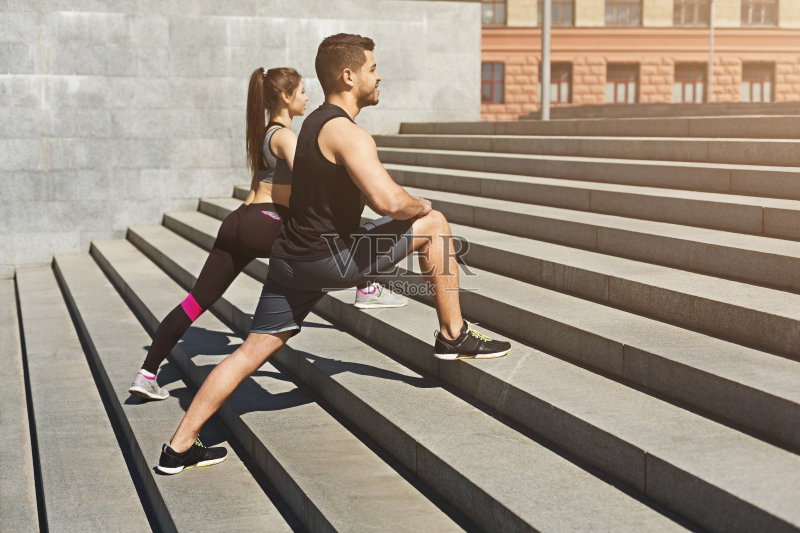 年轻夫妇在城市环境中伸展双腿正版图片素材