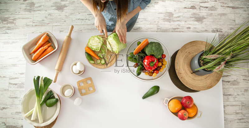 一位年轻妇女正在厨房里准备沙拉。正版图片素材