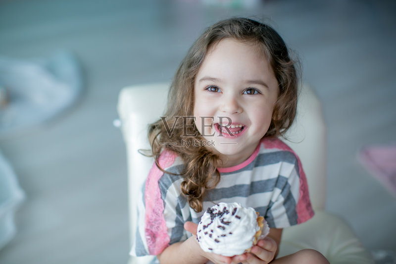 5-7岁的女孩在沙发上吃蛋糕正版图片素材